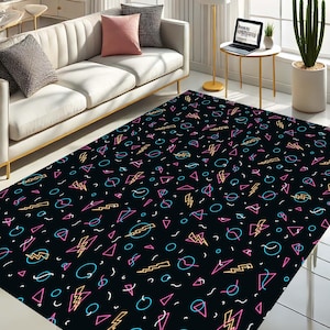May include: A black area rug with a geometric pattern of pink, blue, and yellow lightning bolts, circles, and triangles on a black background.