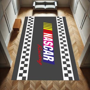May include: A grey and black chequered rug with the words "NASCAR Racing" in colourful letters. The rug has a black border with white chequered squares.