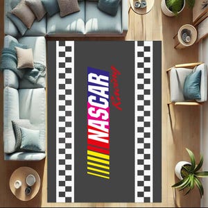 May include: A grey area rug with a black and white chequered border. The centre of the rug features a colourful NASCAR Racing logo.
