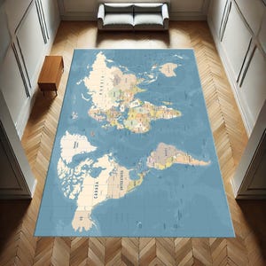 May include: A rectangular area rug featuring a detailed world map design. The rug has a light blue background with beige and colorful continents, countries, and oceans. The rug is placed on a wooden floor in a room with a sofa and a side table.