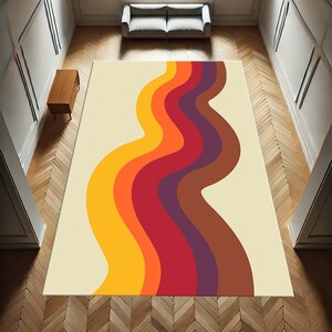 Pode incluir: Um tapete de estilo retro com um padr&atilde;o ondulado em tons de laranja, amarelo, vermelho, roxo e marrom sobre um fundo creme.