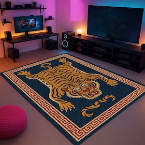 May include: A rectangular rug with a tiger design. The rug features a navy blue background with a detailed illustration of a tiger in shades of gold, brown, and cream. The border is a repeating geometric pattern in red and cream.