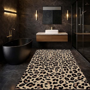 May include: A rectangular rug with a leopard print pattern in a bathroom setting. The rug features a tan background with dark brown spots. The bathroom has a black bathtub, dark walls, and gold fixtures.