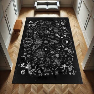 Pode incluir: Tapete preto e branco com um design detalhado de v&aacute;rias criaturas, plantas e s&iacute;mbolos. O tapete apresenta uma caveira, uma borboleta, um morcego, uma lib&eacute;lula, um veado, um unic&oacute;rnio e outros elementos.