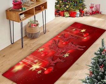 Op de afbeelding: Een rechthoekige rode kerstlopermat met rendiersilhouetten, ornamenten en sneeuwvlokken. De loper heeft een gradiëntontwerp met gouden accenten en is ontworpen voor de feestdagen. De loper ligt op een houten vloer.