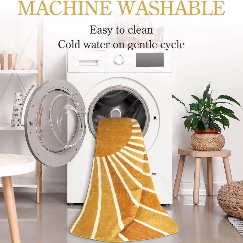 Pu&ograve; includere: Un tappeto a fantasia gialla e bianca con un disegno a raggiera &egrave; parzialmente all'interno di una lavatrice. Il testo "MACHINE WASHABLE" e "Easy to clean Cold water on gentle cycle" sono visibili.
