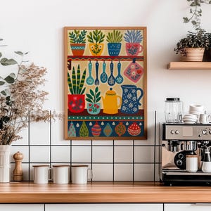 May include: A framed kitchen-themed art print featuring colorful potted plants, utensils, and a teapot. The artwork has a warm color palette with a wooden frame. The print is displayed in a kitchen setting with a coffee machine and mugs.