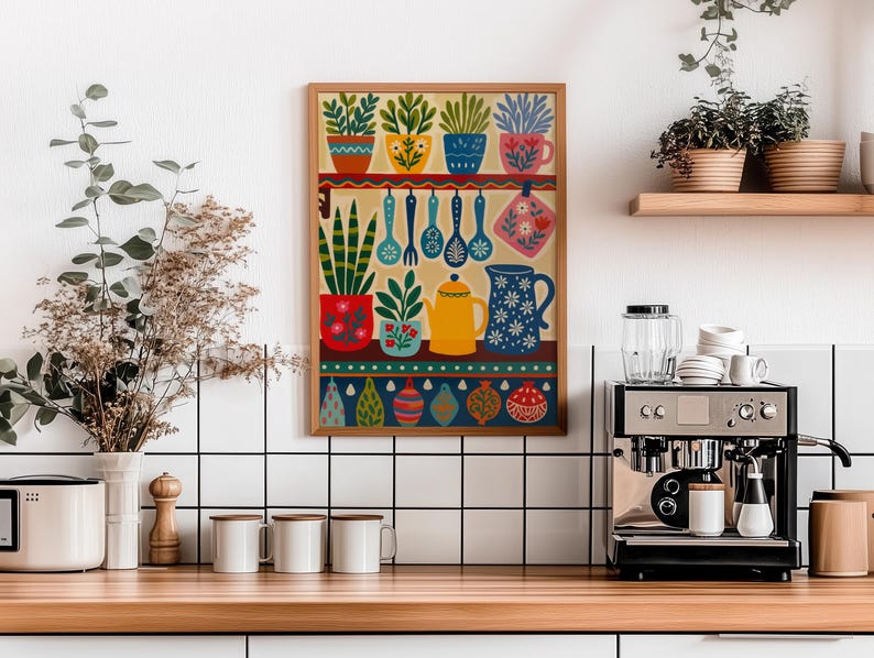 May include: A framed kitchen-themed art print featuring colorful potted plants, utensils, and a teapot. The artwork has a warm color palette with a wooden frame. The print is displayed in a kitchen setting with a coffee machine and mugs.