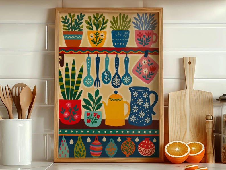 May include: A framed kitchen-themed art print featuring colorful potted plants, utensils, and a teapot. The artwork includes a variety of decorative elements in shades of red, blue, yellow, and green. The print is displayed near wooden cutting boards and fresh oranges.