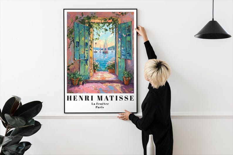 Peut inclure: Une estampe encadr&eacute;e d'une peinture d'Henri Matisse intitul&eacute;e "La Fen&ecirc;tre, Paris". La peinture repr&eacute;sente une vue color&eacute;e d'une fen&ecirc;tre avec des volets ouverts donnant sur un paysage maritime avec des voiliers.