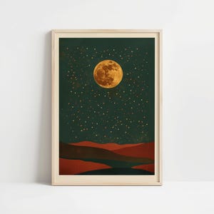 May include: A framed art print featuring a night landscape. A large, golden moon dominates the dark green sky, dotted with numerous stars. Below, layered red and brown hills create a serene, natural scene.