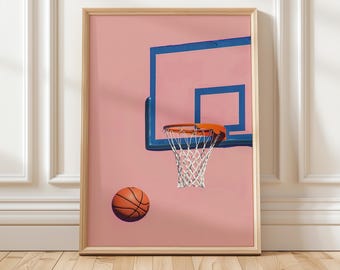 May include: A framed print featuring a basketball hoop with a blue backboard and orange rim against a pink background. A brown basketball is positioned near the hoop. The print is in a wooden frame.