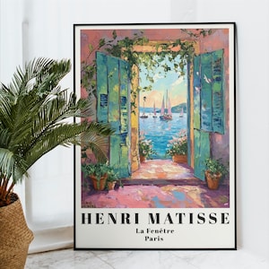Puede incluir: Un póster vintage que presenta una pintura de Henri Matisse titulada "La Fenêtre" que representa una vista colorida de un paisaje marítimo a través de una puerta abierta con contraventanas verdes. La pintura está sobre un fondo rosa claro.