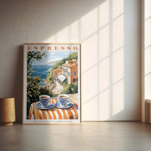 May include: A vintage-style poster with the word "ESPRESSO" in bold orange letters. The poster features a colorful illustration of a seaside town with two cups of coffee on a striped tablecloth.