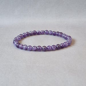 May include: A purple amethyst gemstone bracelet with round beads.