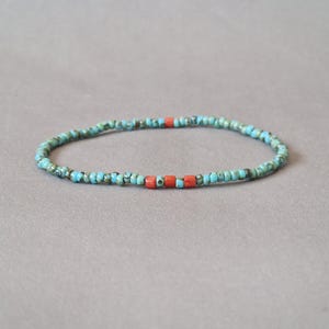 Peut inclure: Un bracelet de perles composé de perles turquoise et bleues, avec quelques perles de couleur corail. Le bracelet est monté sur un cordon élastique et est conçu pour être porté au poignet. Le bracelet mesure environ 18 cm de circonférence.