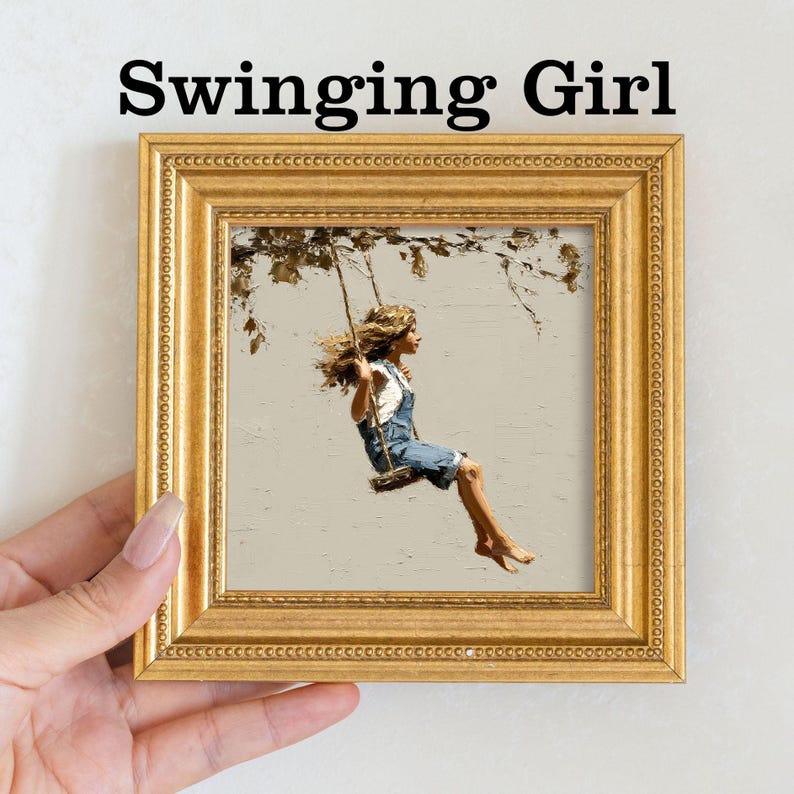 Pu&ograve; includere: Un'opera d'arte incorniciata intitolata "Swinging Girl" raffigura una giovane persona su un'altalena. L'opera d'arte &egrave; in una cornice dorata. La persona indossa una tuta di jeans e una camicia bianca. Lo sfondo &egrave; di colore neutro con rami di alberi.