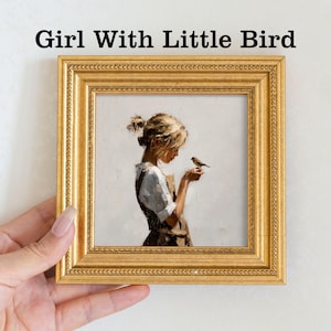 Pu&ograve; includere: Stampa incorniciata intitolata "Girl With Little Bird". L'opera raffigura una giovane persona con i capelli biondi che tiene in mano un uccellino. La cornice &egrave; dorata con un bordo dettagliato. Lo sfondo &egrave; di colore neutro.