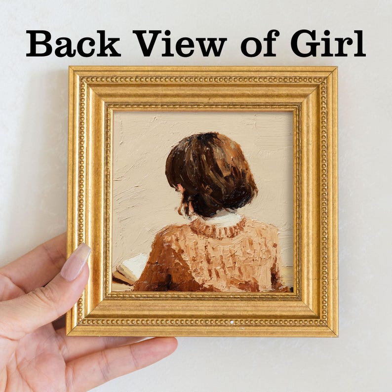 Pu&ograve; includere: Un dipinto incorniciato con una cornice dorata e ornata. Il dipinto raffigura la schiena di una persona con capelli castani corti che indossa un maglione marrone, che legge un libro. Il testo "Back View of Girl" &egrave; in alto.