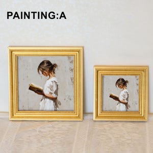 Pu&ograve; includere: Due dipinti incorniciati con cornici dorate. I dipinti raffigurano una persona che legge un libro, che indossa un vestito bianco. Il testo "PAINTING:A" &egrave; nella parte superiore dell'immagine. Le cornici sono rettangolari e hanno un bordo decorativo.