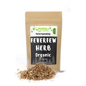 Op de afbeelding: Een bruine papieren zak met het opschrift "Feverfew Herb Organic" met een hoop gedroogde kruiden ervoor. De zak heeft een wit etiket met de tekst "100% Natural" en de merknaam "Forestgoodsbg".