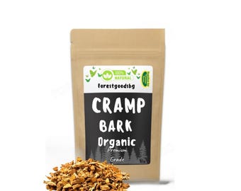 May include: A brown paper bag with a black label that reads "Cramp Bark Organic Premium Grade" next to a pile of brown, dried bark pieces. The bag has a green and white label that says "100% Natural" and "Forestgoodsbg".