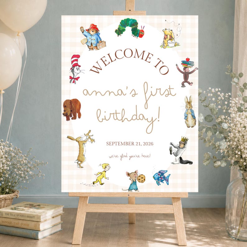 May include: A rectangular welcome sign on a wooden easel featuring a light beige checkered background. The text reads: WELCOME TO anna's first birthday! SEPTEMBER 21, 2026 we're glad you're here! It is decorated with various storybook character illustrations.