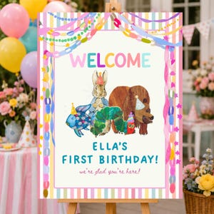 May include: A rectangular welcome sign featuring a colorful border of streamers and balloons. The center displays illustrations of a rabbit, a brown bear, a blue fish, and a green caterpillar, all wearing party hats. Text reads: WELCOME ELLA'S FIRST BIRTHDAY! we're glad you're here!