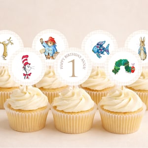 May include: A collection of cupcakes topped with circular paper toppers featuring illustrations of storybook characters including a cat in a hat, a bear, a fish, a caterpillar, and a rabbit, with one topper reading Happy Birthday Anna 1.