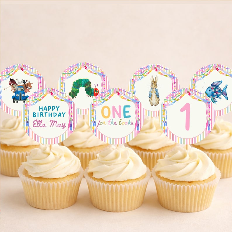 May include: A set of round cupcake toppers featuring colorful illustrations of storybook characters, including a blue truck with animals, a green caterpillar, a rabbit, and a blue fish, with text reading Happy Birthday Ella May and ONE for the books.