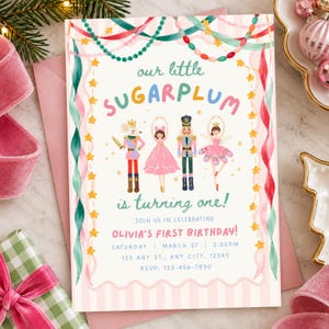 May include: A rectangular birthday invitation card featuring a Nutcracker theme with illustrations of a mouse, a ballerina, a nutcracker, and a fairy. The text reads: our little SUGARPLUM is turning one! JOIN US IN CELEBRATING OLIVIA'S FIRST BIRTHDAY!