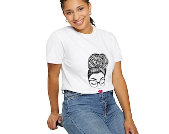 May include: White t-shirt with a black and white graphic of a woman's face with the words "Beautiful, Fearless, Brave, Confident, Fierce" surrounding her hair.