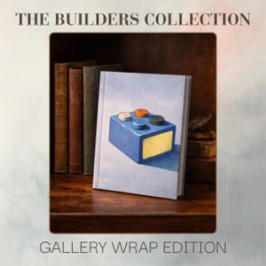 Op de afbeelding: Een gallery wrap editie print getiteld "The Builders Collection". Het kunstwerk toont een blauw boek met een geschilderde afbeelding van een blauwe bouwsteen met kleurrijke noppen. Het boek staat op een houten plank met andere boeken.