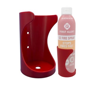 May include: Red plastic wall mount holder for a fire extinguisher spray bottle. The bottle is labeled "First Alert EZ Fire Spray Stops Fires Fast".
