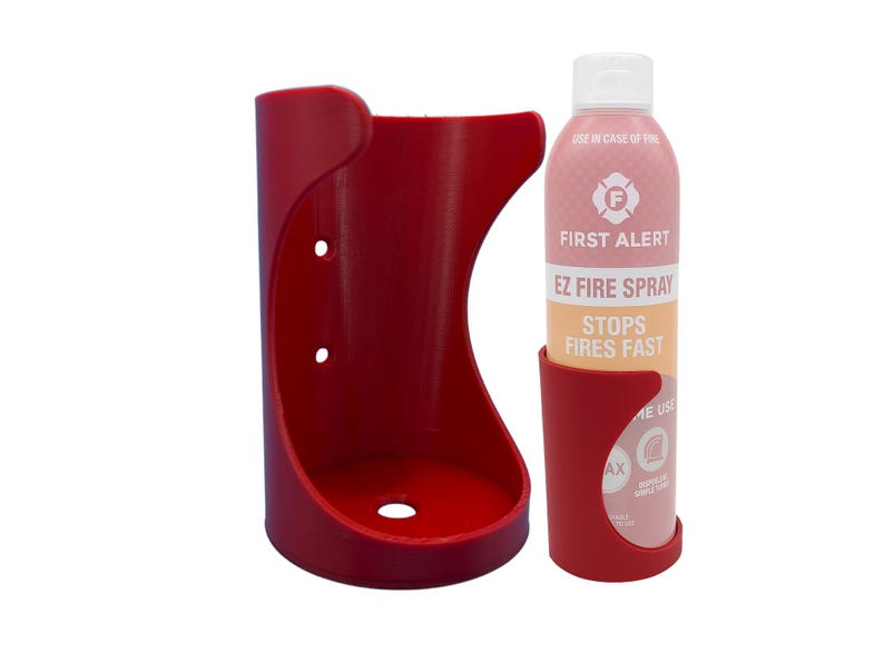 May include: Red plastic wall mount holder for a fire extinguisher spray bottle. The bottle is labeled "First Alert EZ Fire Spray Stops Fires Fast".