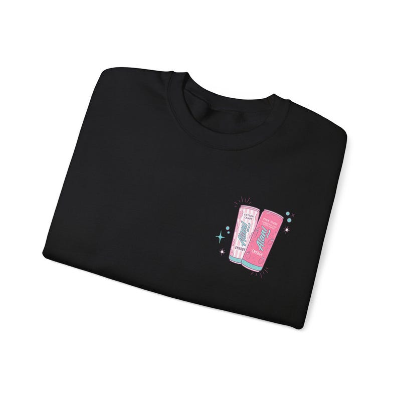 May include: Black sweatshirt featuring a small graphic of two energy drink cans. The cans are pink and white with the text "Always Energy" and "Cotton Candy" and "Pink Blast" printed on them. The design includes starbursts.