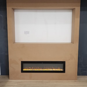 May include: A modern fireplace with a black frame and a realistic flame effect. The fireplace is built into a wall with a large rectangular opening above it.