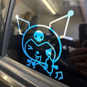 May include: A blue and white vinyl sticker of a cartoon character with a skull on its head, winking, and sticking its tongue out. The character is holding a bottle of what appears to be a beverage.
