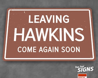 May include: A rectangular brown metal sign with white text that reads "LEAVING HAWKINS COME AGAIN SOON". The sign has a white border and is slightly distressed. The bottom right corner has the text "Deep Fried SIGNS".