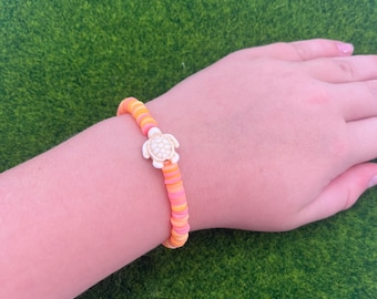 Pulsera de cuentas de arcilla rosa, amarilla y naranja con tortuga