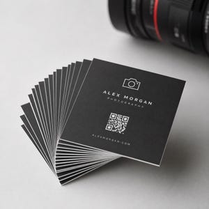 Close up of the back of a square business card with a crisp black QR code that links to a booking page.