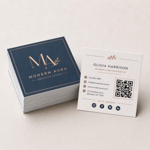 Two square business cards side by side comparing the soft matte finish with the high gloss finish in natural light.