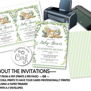 May include: Baby shower invitations with a watercolor woodland animal theme. The invitations feature a green and white leaf border and include event details. A printer, paper cutter, and striped paper are also visible.