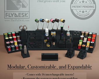 May include: A black modular fly tying station with various tools and spools of thread. The station includes interchangeable inserts and is expandable. The text on the image says "Patent Pending".