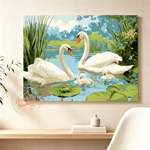 May include: A paint by numbers canvas print featuring two white adult swans and three small cygnets swimming in a blue pond. The scene includes green lily pads, tall reeds on the left, and lush foliage in the background. A circular logo reads Paint By Numbers.
