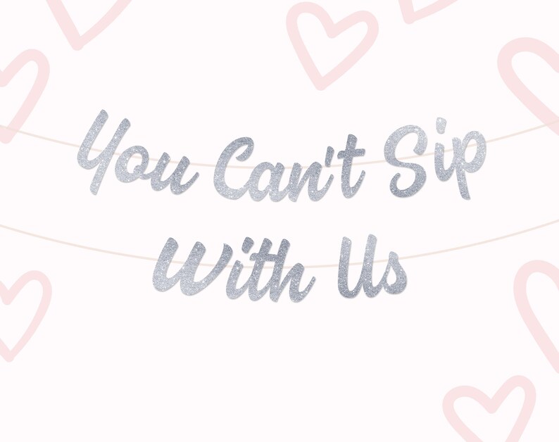 May include: A banner with the phrase "You Can't Sip With Us" in silver glitter lettering, strung across a white background. Light pink heart outlines are scattered around the edges, creating a festive design.