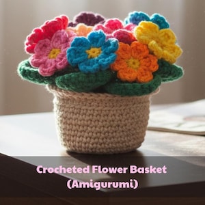Può includere: Un cestino di fiori all'uncinetto con fiori vibranti nei toni del rosso, rosa, blu, arancione e giallo. I fiori sono appoggiati su foglie verdi all'interno di un vaso all'uncinetto beige. Il testo "Crocheted Flower Basket (Amigurumi)" è in basso.
