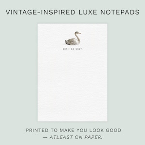 May include: A white notepad with a vintage-style illustration of a swan and the text "DON'T BE UGLY." The notepad is labeled "VINTAGE-INSPIRED LUXE NOTEPADS" and the text "PRINTED TO MAKE YOU LOOK GOOD - ATLEAST ON PAPER."