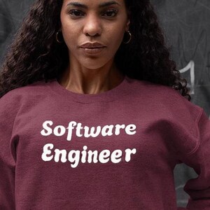 May include: A maroon sweatshirt with the text "Software Engineer" in white retro-style lettering.