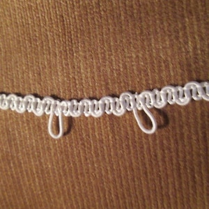 May include: White trim with loops for curtains or other home decor projects.